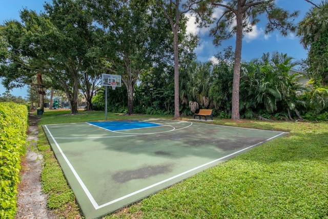 view of sport court with a lawn