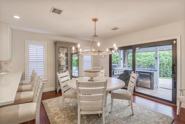 dining room featuring dark hardwood / wood-style floors and an inviting chandelier