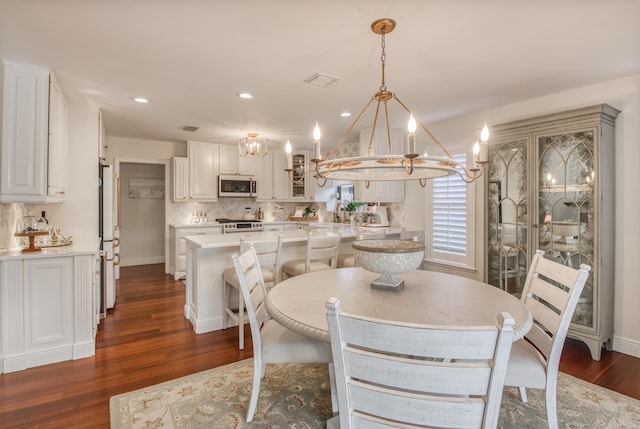 dining area featuring dark hardwood / wood-style floors and an inviting chandelier