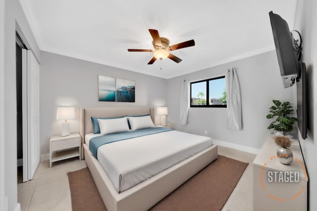 tiled bedroom featuring ceiling fan, a closet, and ornamental molding