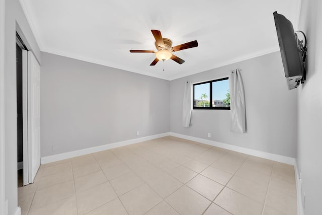 spare room featuring ceiling fan, light tile patterned floors, and crown molding