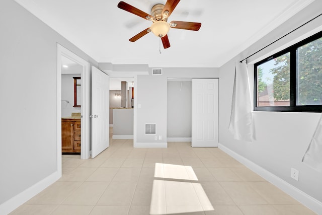 spare room featuring ceiling fan, light tile patterned flooring, and ornamental molding