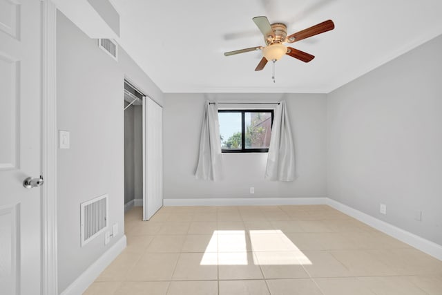 spare room with ceiling fan and light tile patterned floors