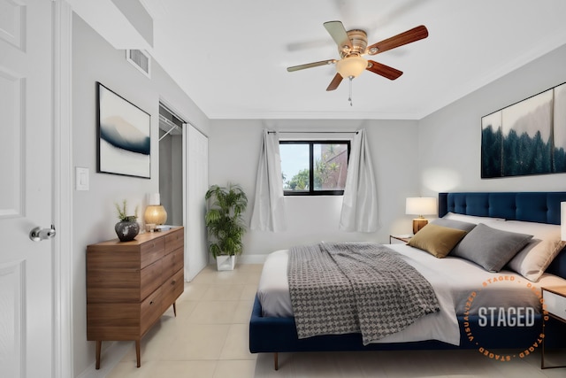 tiled bedroom featuring ceiling fan and a closet