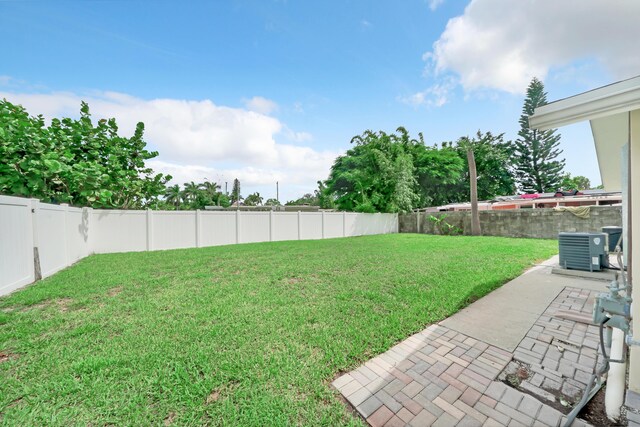 view of yard featuring central AC unit and a patio