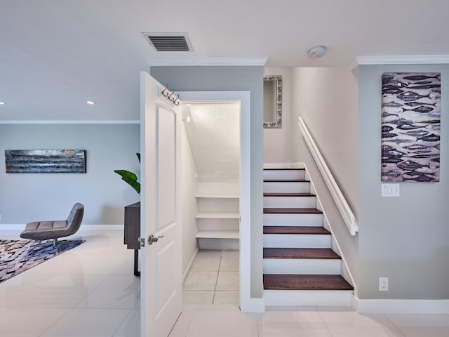 stairs with ornamental molding and tile patterned floors