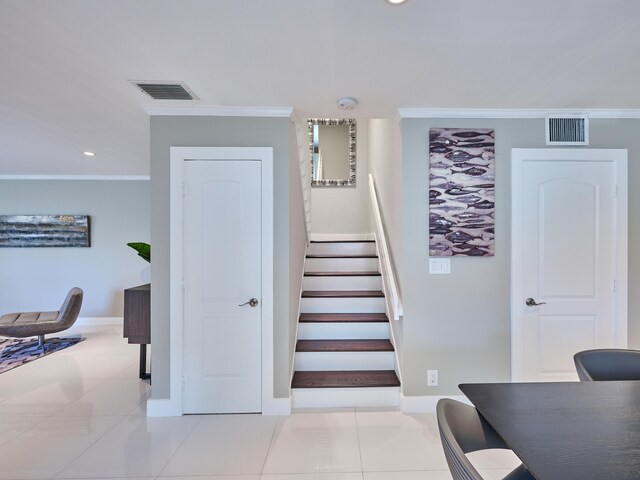 stairs featuring crown molding and tile patterned flooring