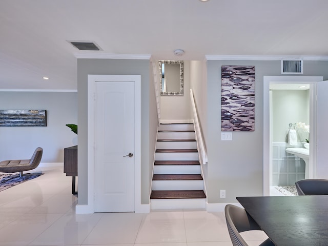 stairway with crown molding and tile patterned flooring