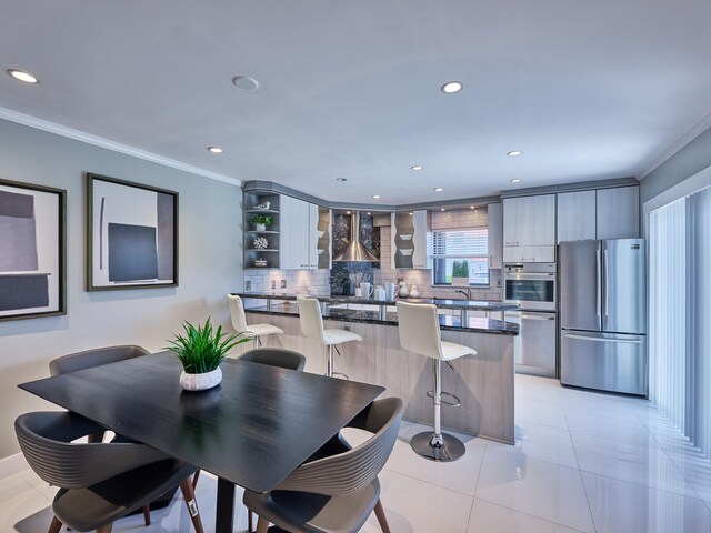 dining room featuring light tile patterned floors and crown molding