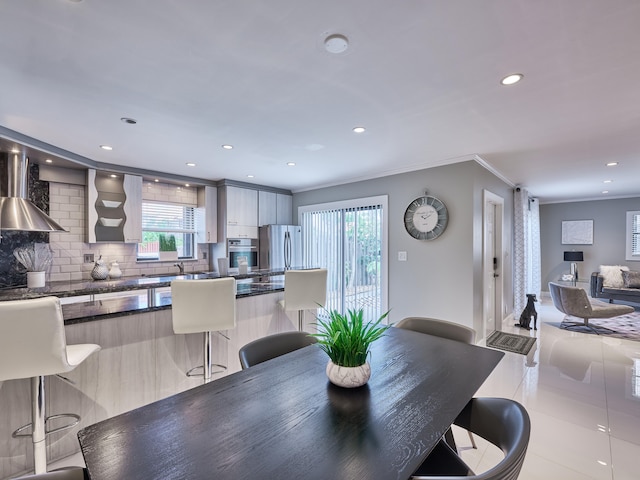 dining area with light tile patterned floors and ornamental molding