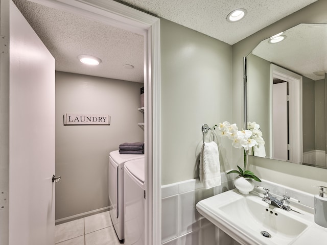 bathroom with washer and clothes dryer, tile patterned flooring, a textured ceiling, and sink