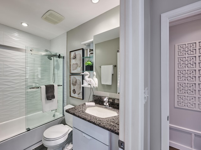 full bathroom featuring bath / shower combo with glass door, vanity, and toilet