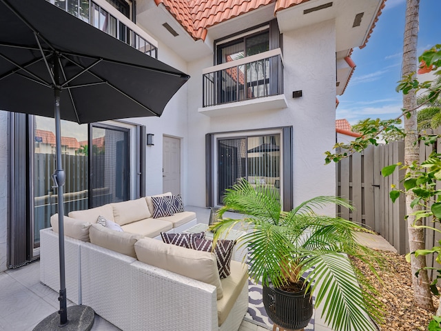 view of patio with outdoor lounge area and a balcony