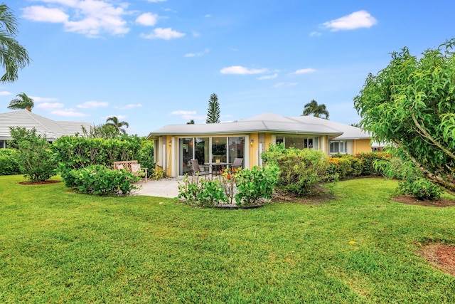 back of property featuring a lawn and a patio