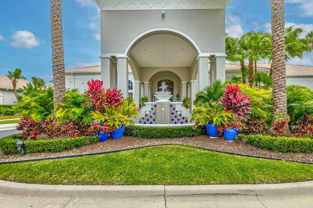 property entrance featuring a tiled roof and stucco siding