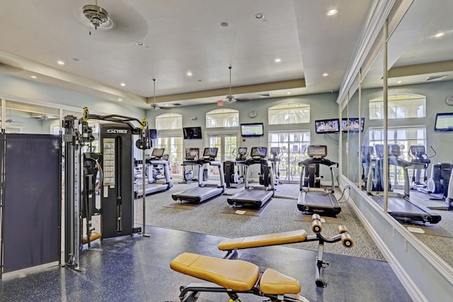 workout area featuring ceiling fan and a raised ceiling