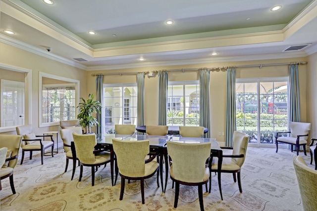 dining room with a tray ceiling, plenty of natural light, and ornamental molding