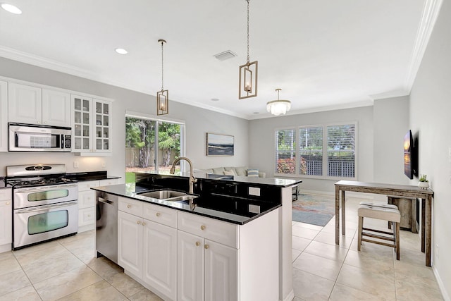 kitchen featuring light tile patterned floors, dark countertops, appliances with stainless steel finishes, crown molding, and a sink