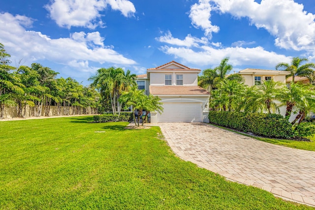 view of front of property with decorative driveway, a tile roof, stucco siding, a garage, and a front lawn