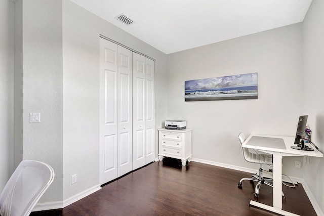 office space with visible vents, dark wood finished floors, and baseboards