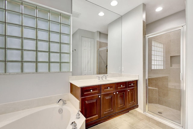 bathroom with tile patterned flooring, vanity, and separate shower and tub