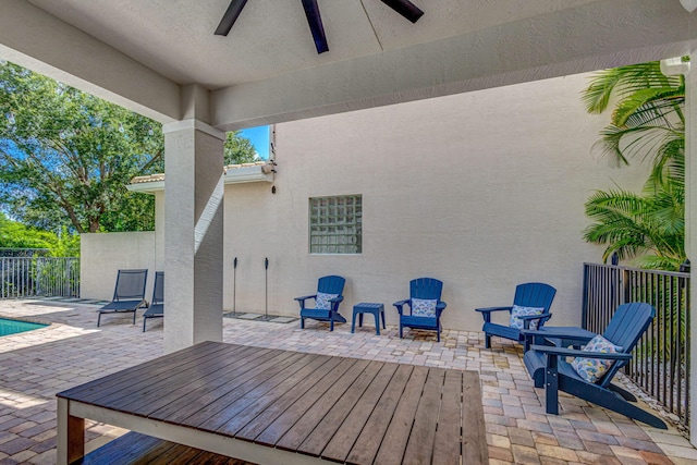 view of patio with ceiling fan and fence