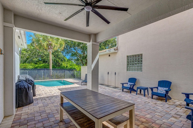 view of patio featuring ceiling fan, area for grilling, and a fenced in pool