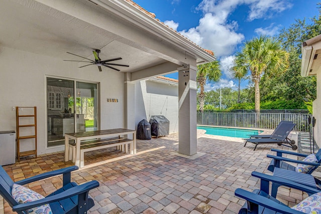 view of patio / terrace featuring area for grilling, ceiling fan, and a fenced in pool