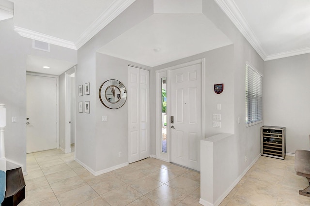 tiled foyer featuring ornamental molding and beverage cooler