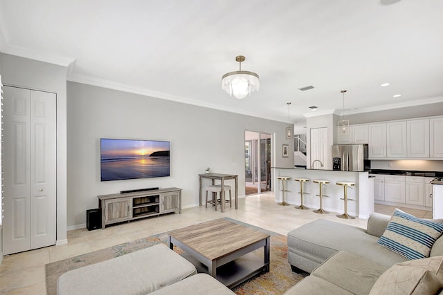 tiled living room featuring ornamental molding and an inviting chandelier