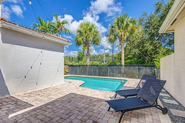 view of swimming pool featuring a patio, fence, and a fenced in pool