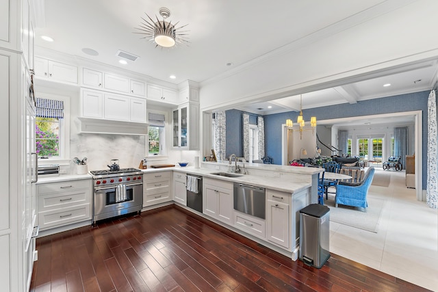 kitchen with appliances with stainless steel finishes, dark wood-type flooring, sink, pendant lighting, and white cabinets