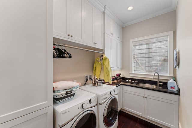 laundry area featuring cabinets, dark hardwood / wood-style flooring, ornamental molding, sink, and washing machine and clothes dryer