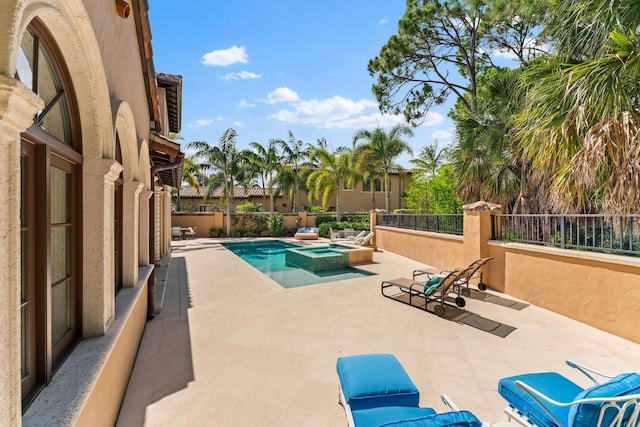 view of pool with a patio area and an in ground hot tub