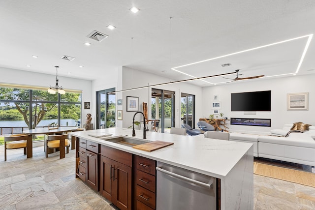 kitchen with an inviting chandelier, a healthy amount of sunlight, stainless steel dishwasher, and sink