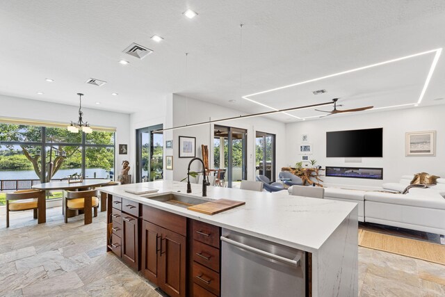 6787 Bayshore Dr, Lake Worth, FL 33462 - kitchen featuring a sink, stainless steel dishwasher, a ceiling fan, stone tile floors, and plenty of natural light
