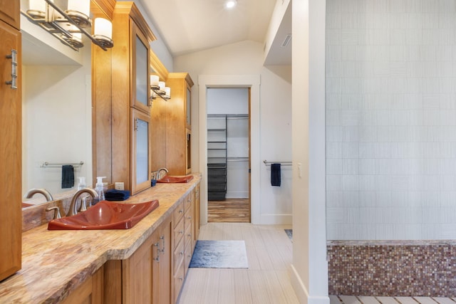 bathroom with tile patterned floors, lofted ceiling, and vanity