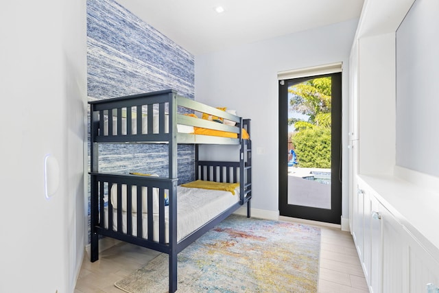 6787 Bayshore Dr, Lake Worth, FL 33462 - bedroom with access to outside, an accent wall, baseboards, and light wood-type flooring