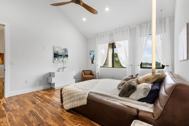 bedroom featuring hardwood / wood-style floors, high vaulted ceiling, and ceiling fan