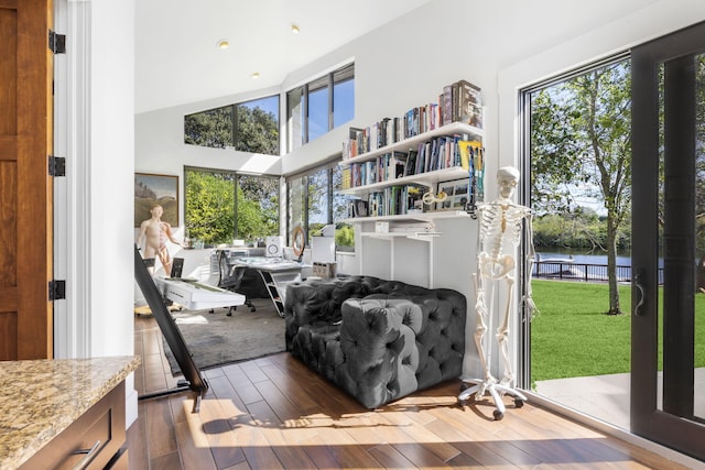 6787 Bayshore Dr, Lake Worth, FL 33462 - living area featuring wood-type flooring, a water view, and a high ceiling