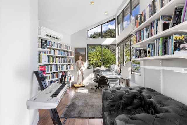 home office featuring high vaulted ceiling, a wall mounted AC, and wood-type flooring