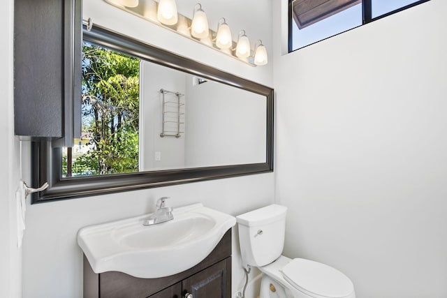 bathroom featuring toilet, a wealth of natural light, and vanity