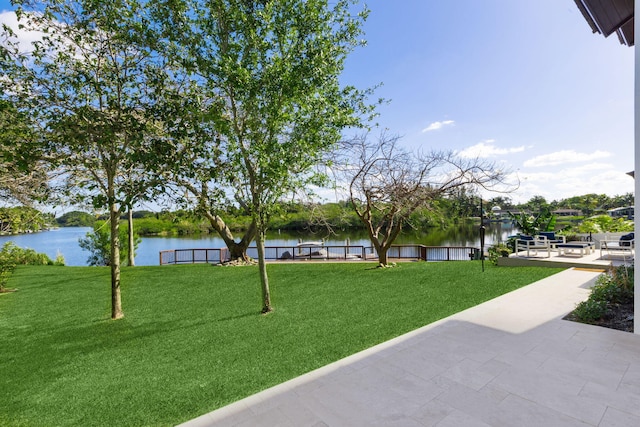 surrounding community featuring a water view and a lawn