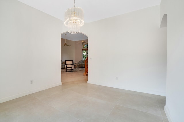 unfurnished room with ceiling fan with notable chandelier and light tile patterned floors