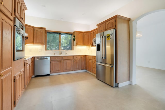 kitchen with sink, light tile patterned floors, backsplash, and stainless steel appliances