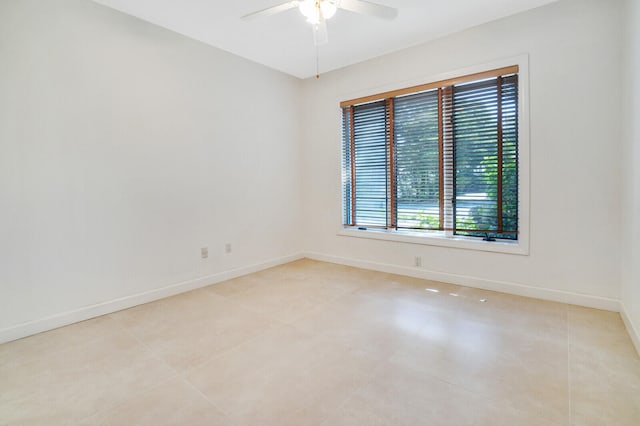 tiled empty room featuring ceiling fan