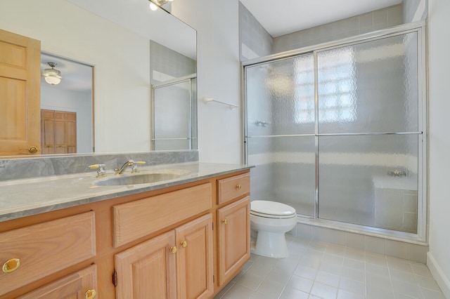 bathroom featuring tile patterned flooring, toilet, vanity, and a shower with shower door