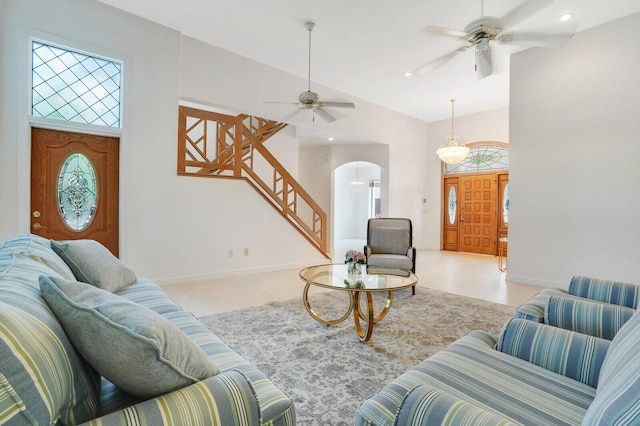 tiled living room with ceiling fan and high vaulted ceiling