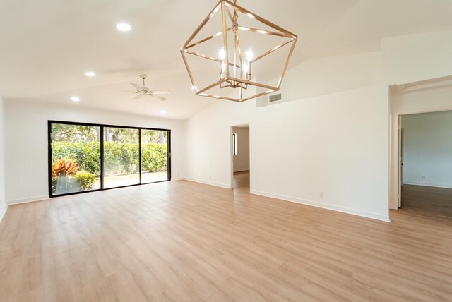 empty room featuring a high ceiling, light hardwood / wood-style flooring, and ceiling fan with notable chandelier