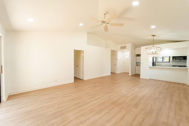 unfurnished living room featuring vaulted ceiling, light hardwood / wood-style floors, and ceiling fan with notable chandelier